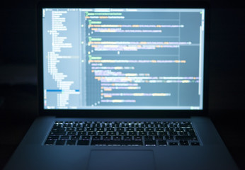 Laptop with an opened screen showing written code. Technology and programming concept.