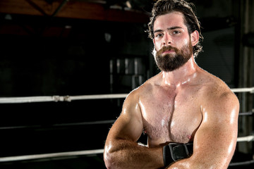 Fototapeta na wymiar Male fighter with beard facial hair and intimidating glare stare with arms folded