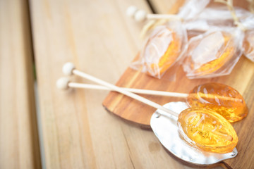 Fototapeta premium Honey caramel candy lollipop on wooden background