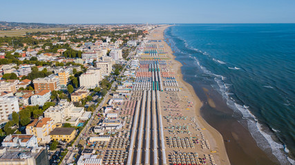 Drone aerial view of the umbrellas and gazebos on Italian sandy beaches. Adriatic coast. Emilia Romagna region - obrazy, fototapety, plakaty