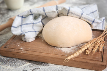 Cutting board with raw dough on kitchen table