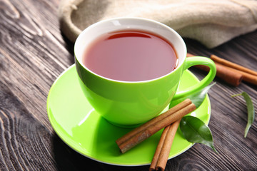 Cup of delicious tea and cinnamon on wooden table. Weight loss concept