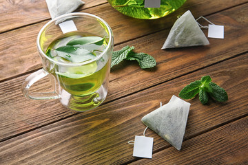Composition with teabags, mint leaves and cup on wooden table. Weight loss concept