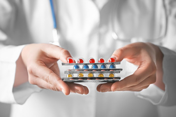 Doctor holding packs with pills in hands, closeup. Weight loss concept