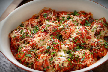 Closeup view of ceramic casserole dish with turkey meatballs, tomato sauce and melted cheese