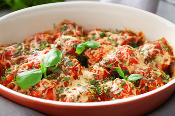 Ceramic casserole dish with delicious turkey meatballs, tomato sauce and melted cheese, closeup