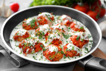 Frying pan with delicious turkey meatballs and sauce on table