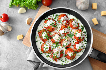 Frying pan with delicious turkey meatballs and sauce on table