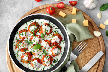 Frying pan with delicious turkey meatballs and sauce on table