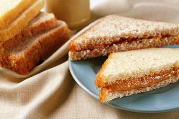 Fototapeta na wymiar Tasty sandwiches with peanut butter on table