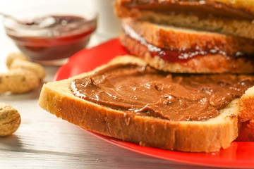 Tasty sandwiches with peanut butter on plate, closeup