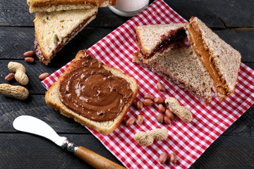 Tasty sandwiches with peanut butter on table