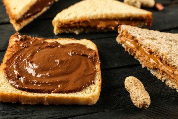 Tasty sandwiches with peanut butter on table