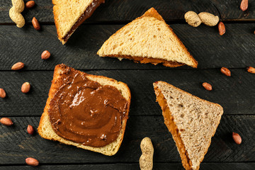 Tasty sandwiches with peanut butter on table