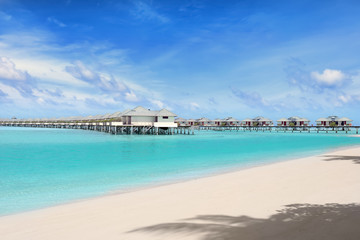 Fototapeta na wymiar Modern beach houses on piles at tropical resort