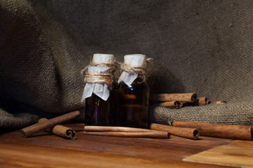 ground cinnamon, essential oil and cinnamon sticks cinnamon on a darck wooden background