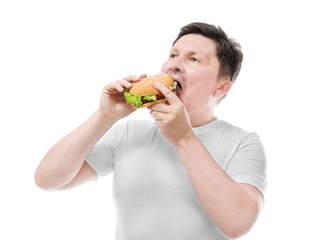 Overweight man eating burger on white background. Diet concept