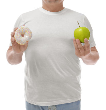 Overweight man with apple and donut on white background. Diet concept