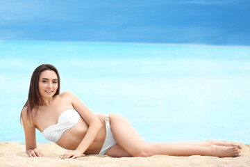 Fototapeta na wymiar Beautiful young woman in bikini on sea beach