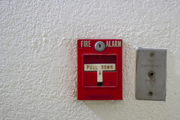 Fototapeta na wymiar Red antique fire alarm button with white wall