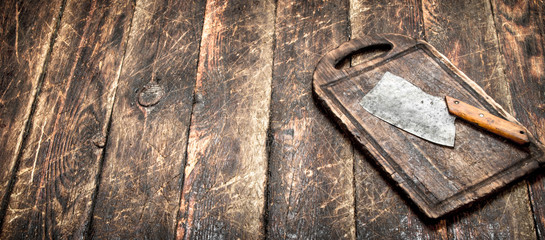 Serving background. Old hatchet on a chopping Board.