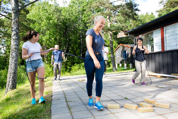 Friends Carrying Ropes While Walking Towards Wooden Blocks On Pa