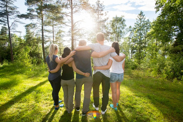 Rear View Of Multiethnic Coworkers Standing Arms Around In Fores