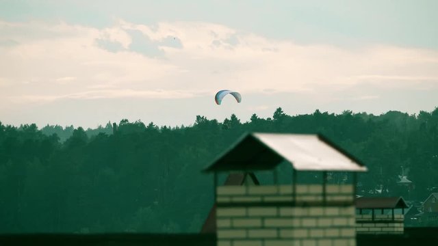 Unknown powered paraglider flying near the town