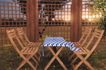wooden furniture with tablecloth in bavarian colors at garden