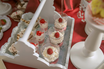 Rustic white wooden tray with small size desserts and cupcakes prepared for an event reception, at the candy bar