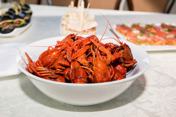 Cooked crayfishes in white plate on table