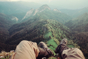 Male explorer sitting in mountains, pov image.
