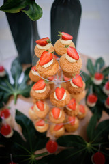 Table with sweet panna cotta and strawberry eclairs