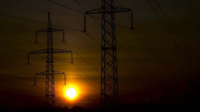 Sunrise on a background of a high-voltage line. Time lapse.