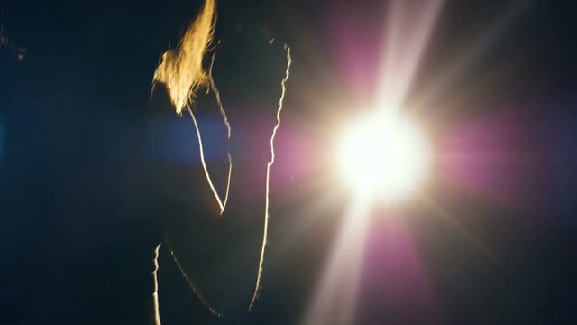 A closeup of a backlit boxer woman training her jabs. 