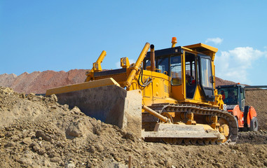 Bulldozer on construction site moving soil