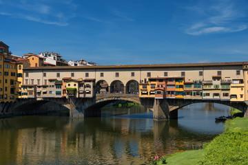 Obraz premium River Arno and famous bridge Ponte Vecchio (The Old Bridge) at sunny summer day. Florence, Tuscany, Italy