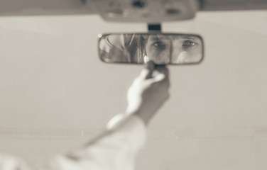 Man in car looking at mirror inside