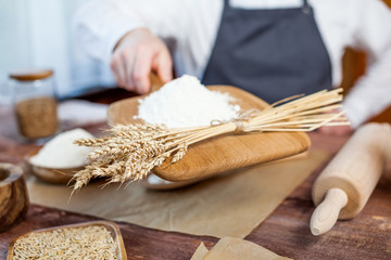 Man holding wheat flour in a bakery close up