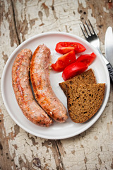 White grilled sausages with tomatoes and brown bread