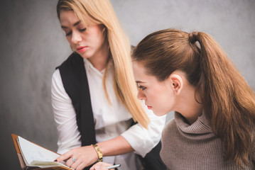 Two pretty women studying together at a library 