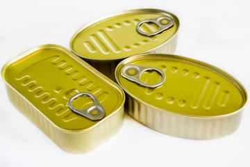 Various cans of canned unopened fish on white background.