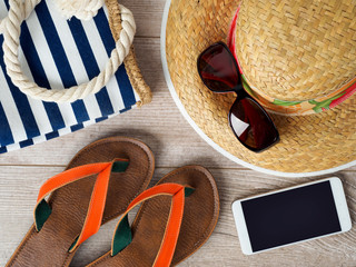 Straw hat, sunglasses, smartphone and slippers