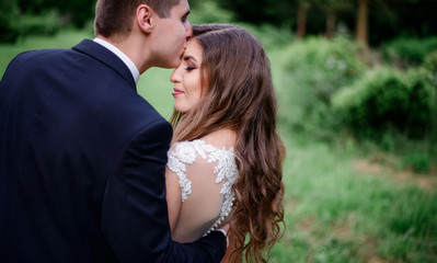 Fototapeta premium Groom kisses bride's forehead tender