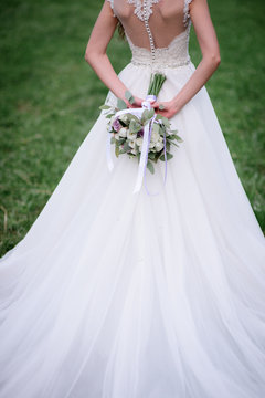 Pretty bride in a white dress stands in the garden