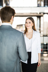 Businessman and Businesswoman shaking hands in office. Business concept