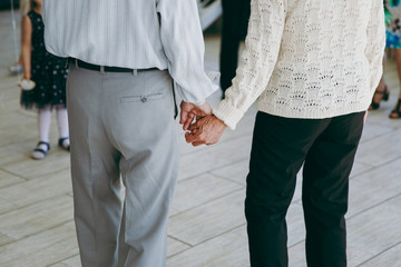 Elderly couple in casual clothes holding hands