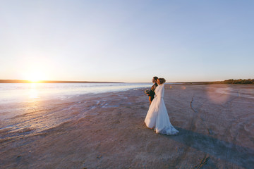 Fototapeta na wymiar Groom and bride on a walk outdoors at the sea