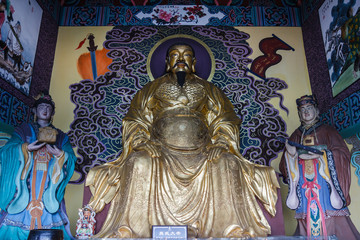 Golden statue of sitting Confucius in a Chinese temple