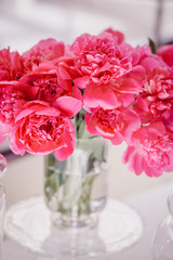 Bouquet of dark pink peonies stands in tha vase